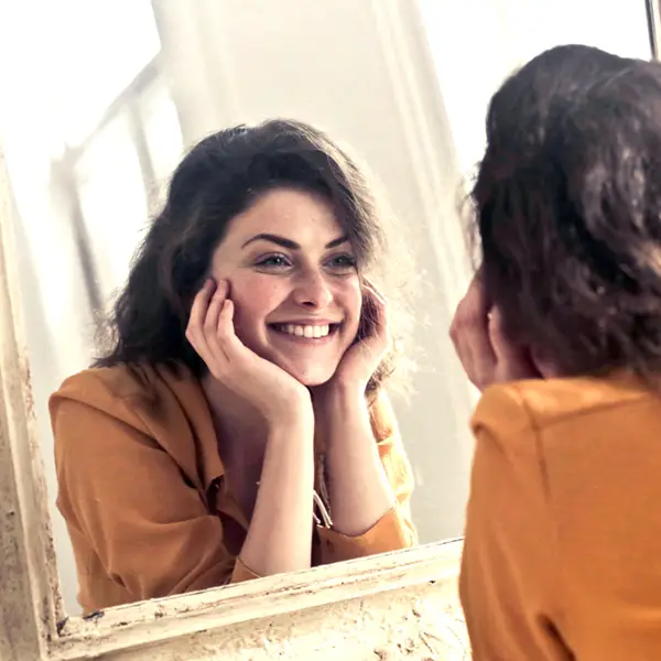 Girl with contacts looking in mirror.